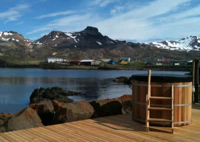 A wooden deck, a hot pot, the sea and mountains