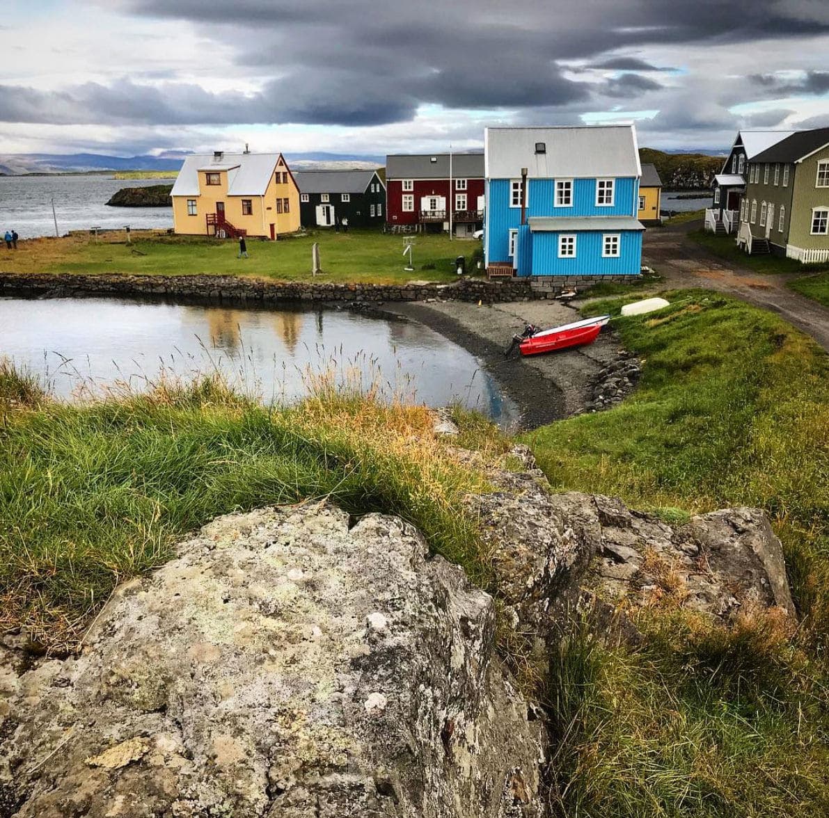 old houses in a village by a cove with big stone in foreground
