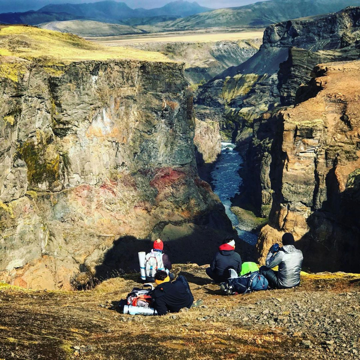 Some persons sitting and looking into a big canyon