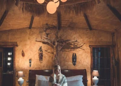 Inside a Rangá hotel room suite, a young women sitting on a bed